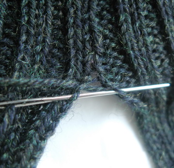 Bei den 2 Linksmaschen in das äussere Glied der 2 Maschen stechen und auf der anderen Seite in das äussere Glied der Linksmaschen einstechen - und zurück. Aufgepasst: die Linksmaschen krellen sich und man muss die Seite auseinandernehmen, so dass man wirklich in das ÄUSSERSTE Glied einsticht.