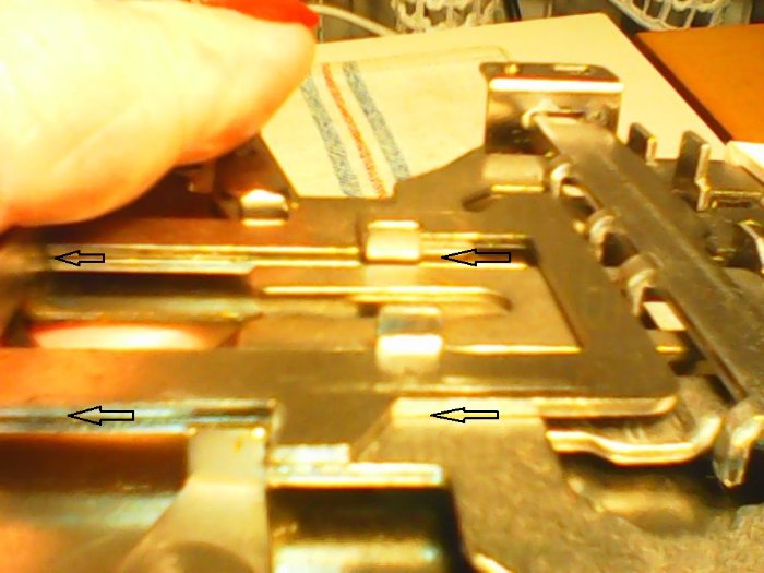 Die schwarzen Pfeile zeigen die Fläsche, die normalerweise Gleiten sollten. Die Bleche sind die Hebel der PART/TUCK/MC-Tasten. Wenn jetzt diese Bleche aufeinander Haften/KLeben, dann verschiebt/nimmt die eine, die anderen Taste mit. --> Also lösen (ggf. mit SANFTER Gewalt hebeln) und oelen --> dann gut.